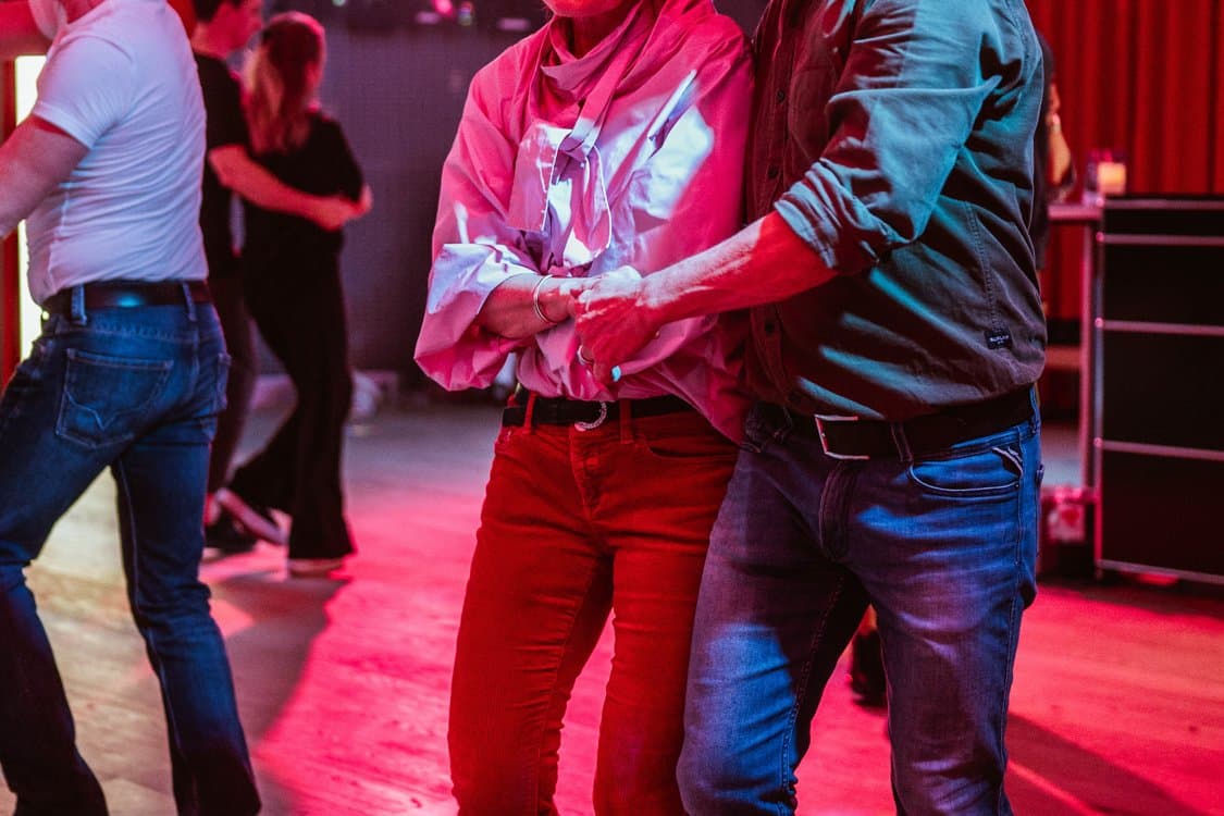 Paar beim Tanzen im warmen Licht der Tanzschule Frieling