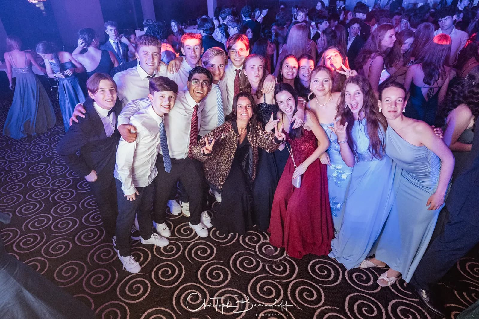 Gruppe Jugendlicher posiert lachend für ein Foto auf der Aftershow-Party.